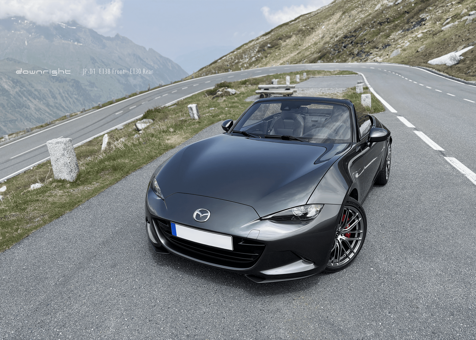 Grey Mazda MX-5 ND with shinny wheels from downright on a mountain road of Grossglockner with scenic background of Alps