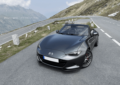 Grey Mazda MX-5 ND with shinny wheels from downright on a mountain road of Grossglockner with scenic background of Alps