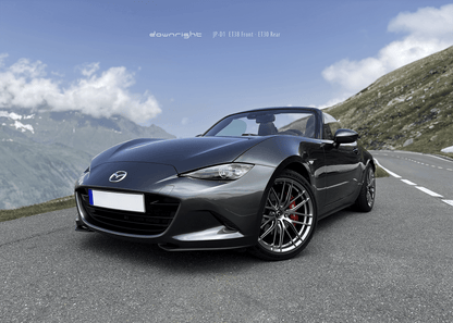 Grey Mazda MX-5 ND with shinny wheels from downright and red Brembo brake caliper parked on a mountain road of Grossglockner with blue sky and clouds
