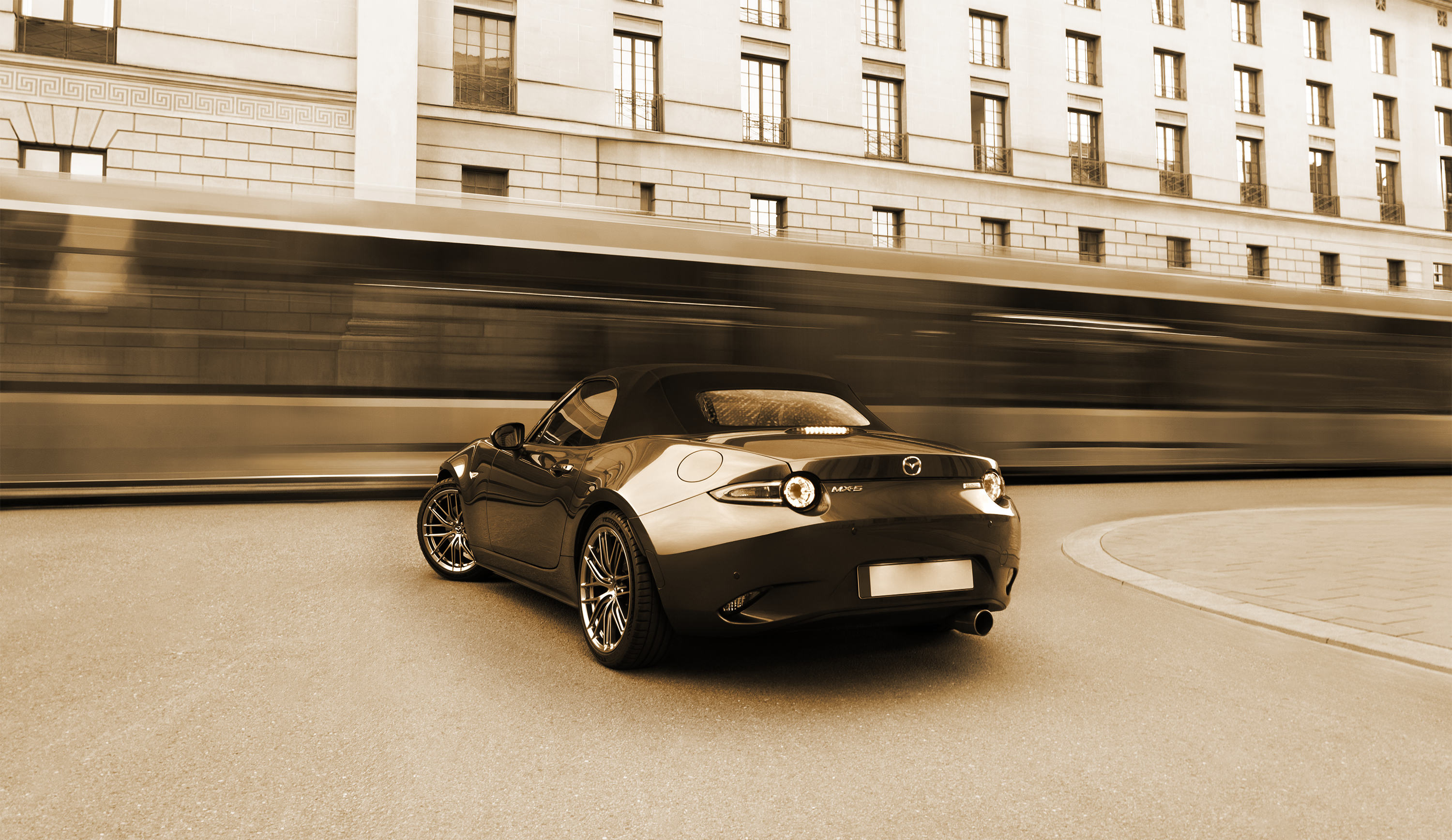 Black convertible car driving on a road with a blurred background